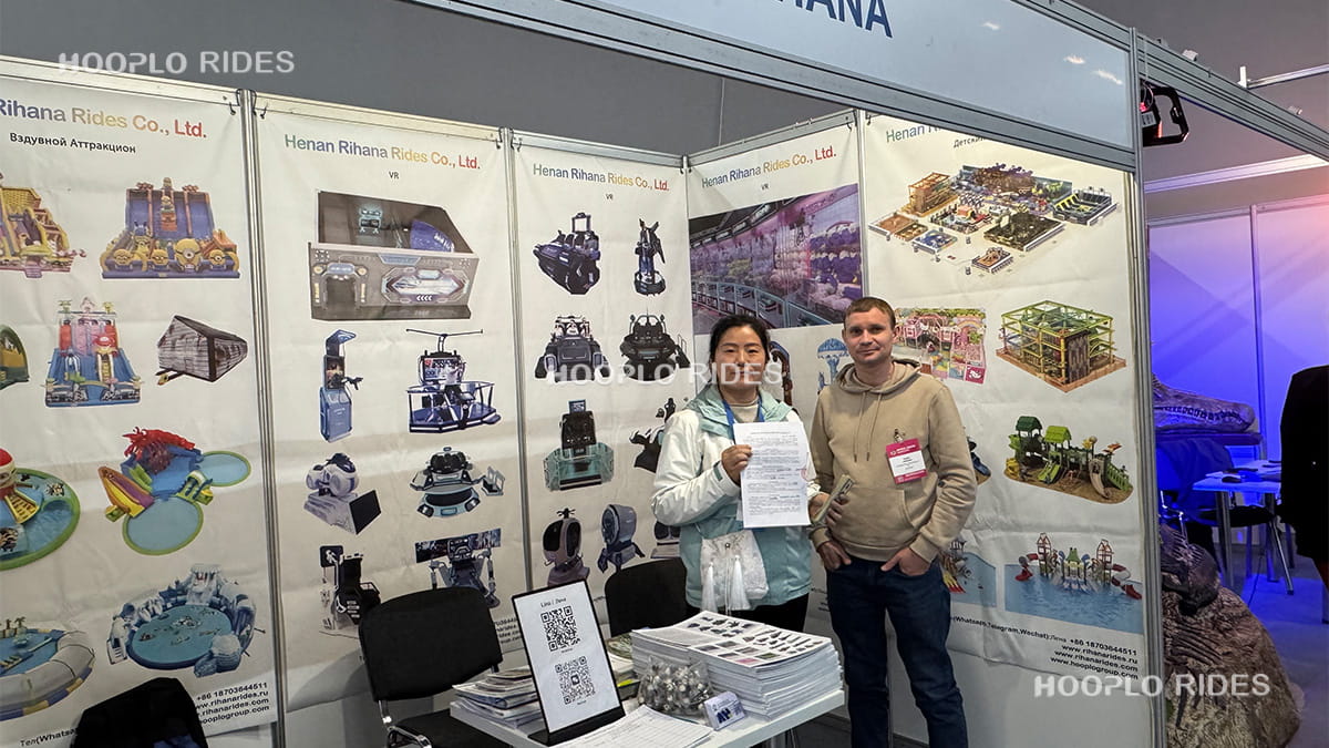 Hooplo Group team and Russian customer holding signed contract after deposit at RAAPA Expo 2025