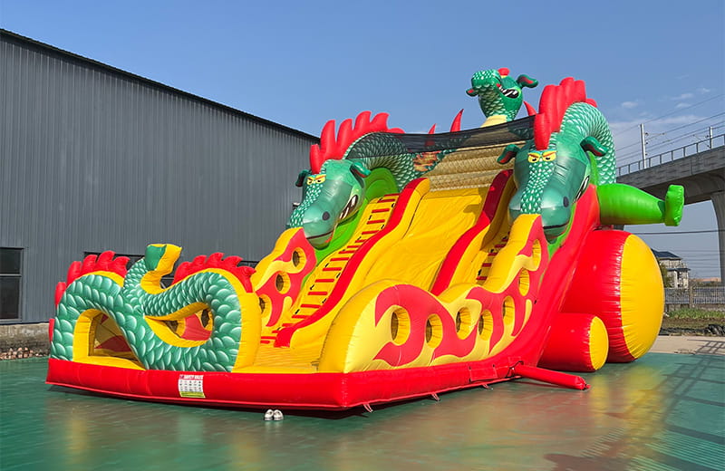 A massive red and green Chinese dragon-shaped inflatable slide with dual lanes, ideal for outdoor festivals and theme parks.