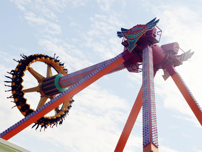 Giant swing amusement ride in operation with safety harnesses and support structure