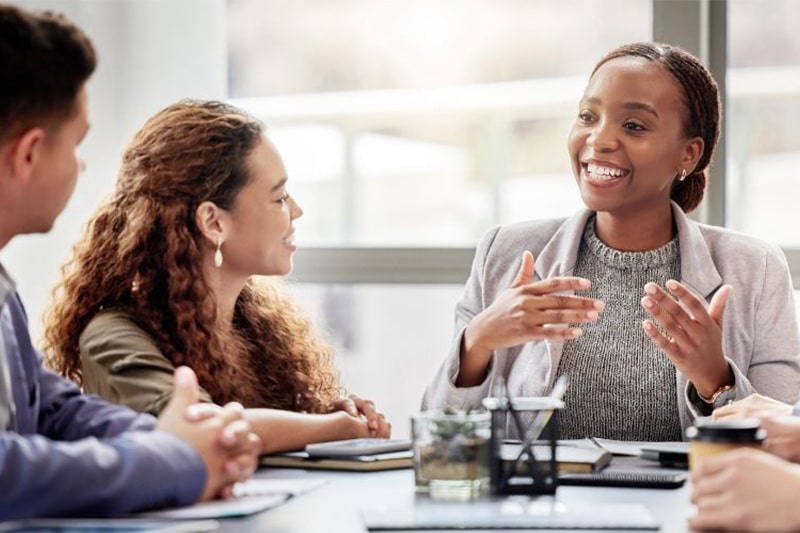 People of different backgrounds discussing together in a meeting room, representing corporate responsibility