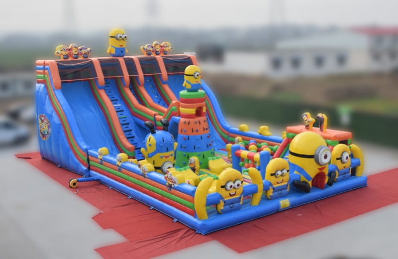 Large yellow cartoon themed inflatable slide combo featuring multiple climbing lanes and a spacious bouncing area for kids.