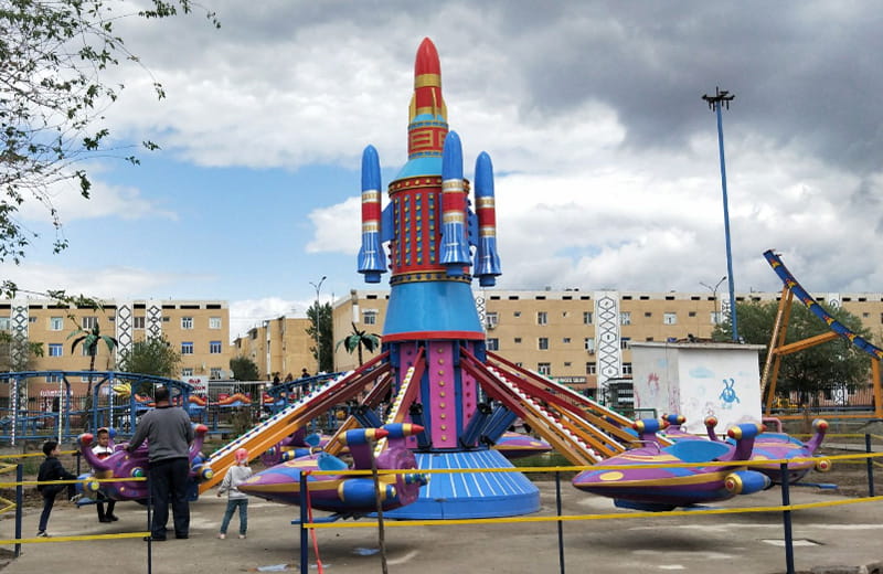 Children getting ready to ride the Self-Control Plane at a customer amusement park in Uzbekistan.